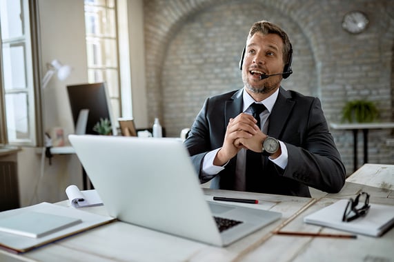 mid-adult-businessman-talking-headset-while-having-online-meeting-office copy